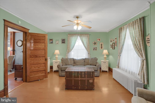 living room featuring radiator, hardwood / wood-style flooring, crown molding, and ceiling fan