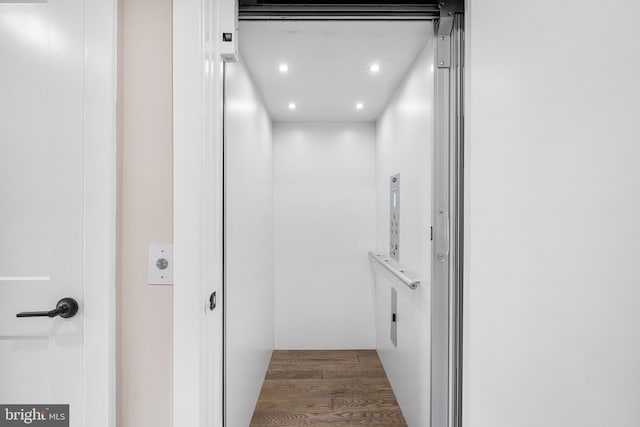 room details with hardwood / wood-style floors and elevator