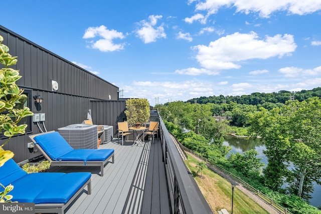 wooden deck featuring a water view and central air condition unit