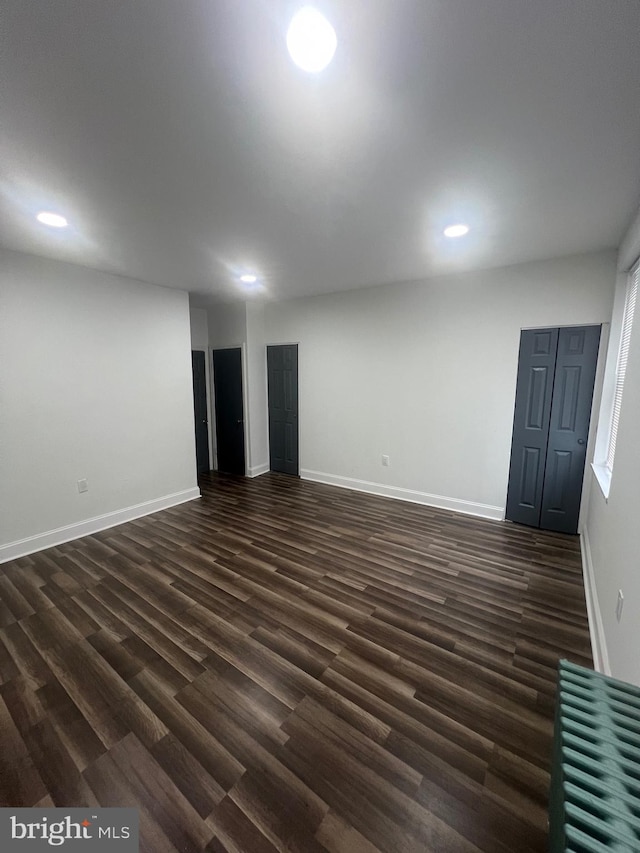 unfurnished living room with dark hardwood / wood-style flooring