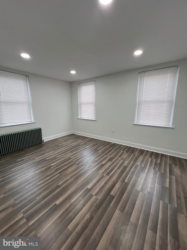 unfurnished room featuring dark hardwood / wood-style floors and radiator