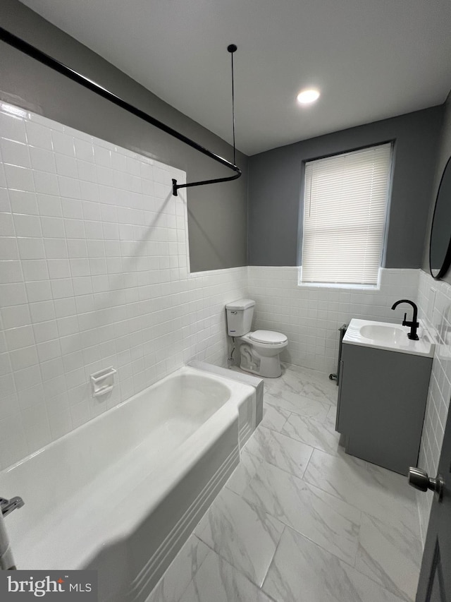 full bathroom featuring vanity, tile walls, tiled shower / bath combo, toilet, and tile patterned flooring