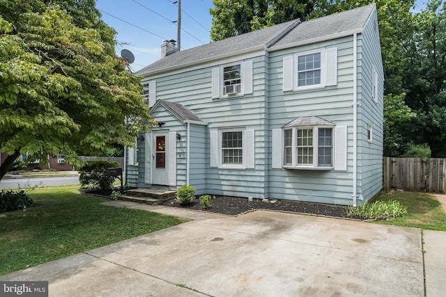 colonial-style house featuring a front yard