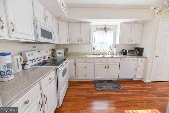 kitchen featuring white cabinetry, sink, and white appliances