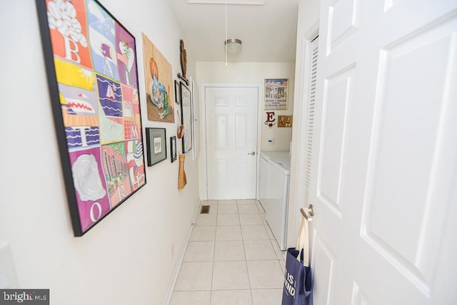 hallway featuring light tile patterned floors and washing machine and dryer