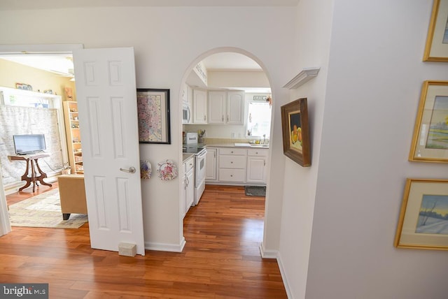 hallway with hardwood / wood-style floors