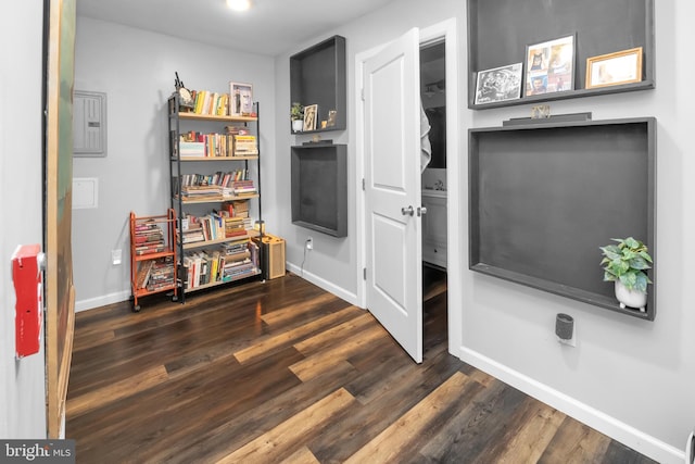 misc room with electric panel and dark hardwood / wood-style flooring