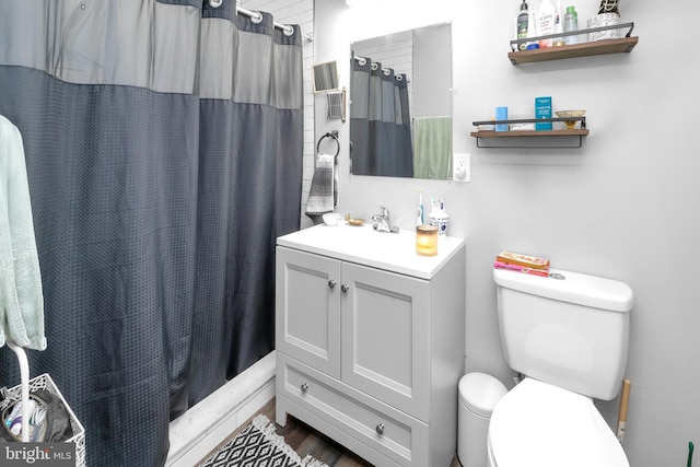 bathroom featuring curtained shower, vanity, wood-type flooring, and toilet