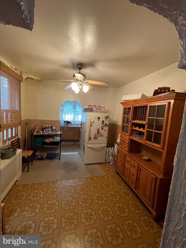 dining room featuring ceiling fan and wood walls