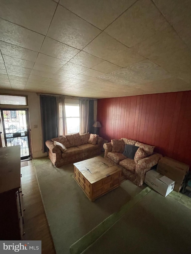 unfurnished living room featuring wood walls