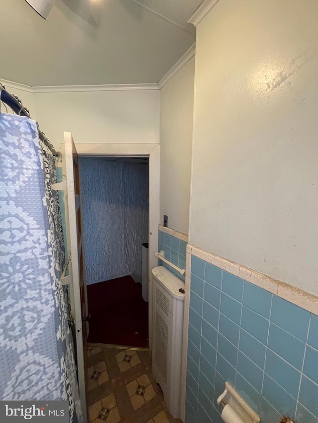 bathroom featuring tile walls and ornamental molding