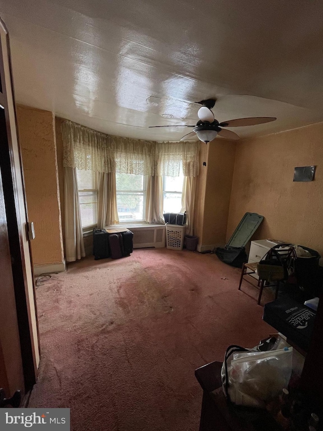 interior space with ceiling fan and carpet flooring