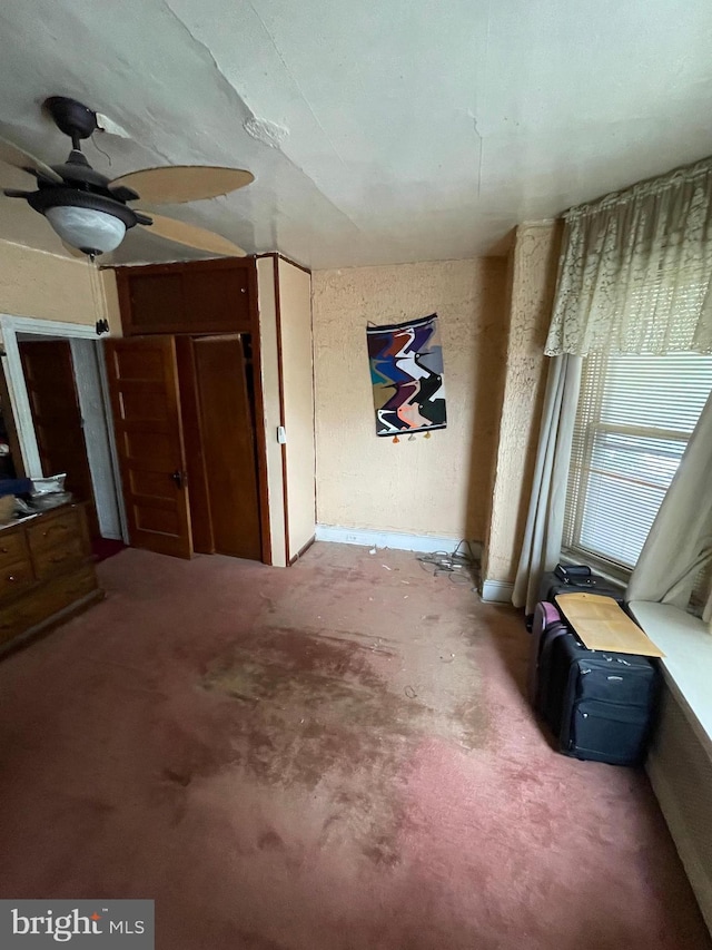 interior space featuring ceiling fan and carpet floors