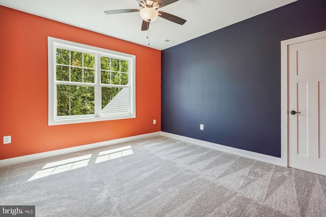 empty room with ceiling fan and light carpet