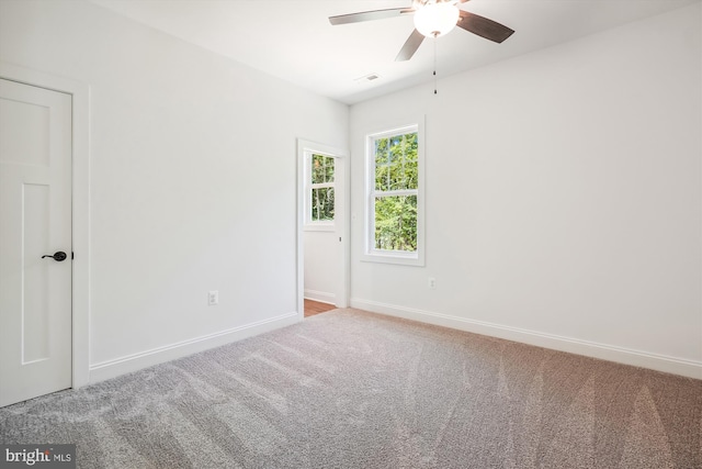 carpeted spare room featuring ceiling fan