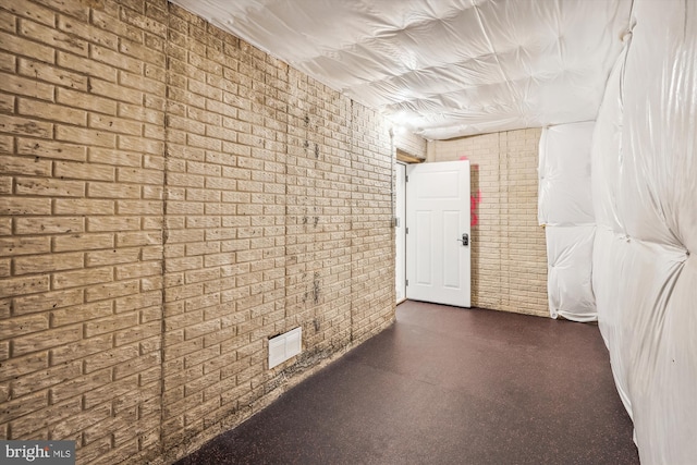 hallway featuring brick wall