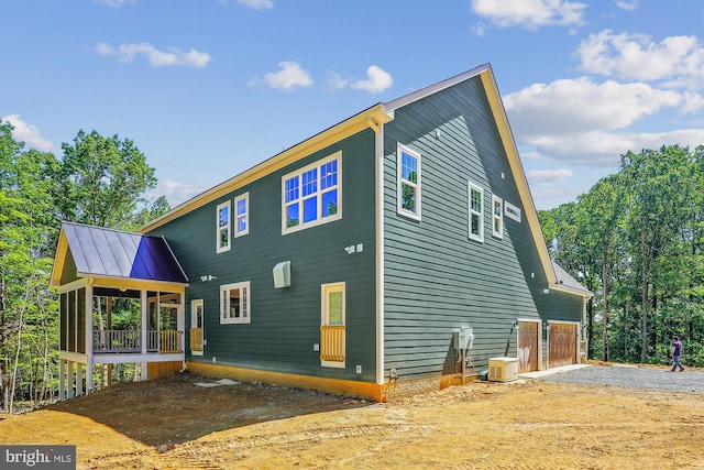 back of house with a garage and a sunroom