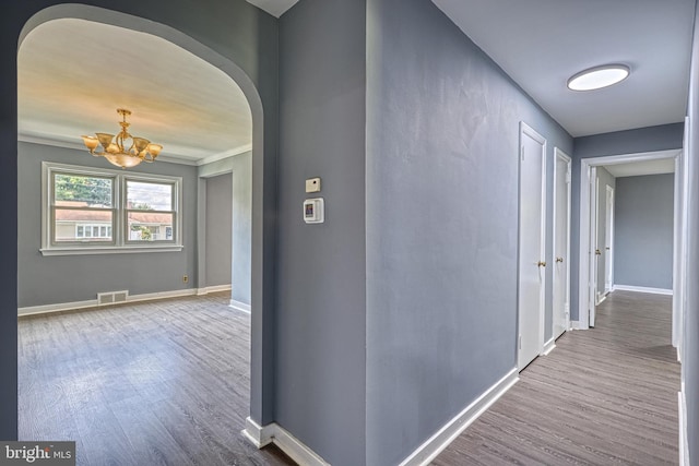 hall featuring hardwood / wood-style floors and an inviting chandelier