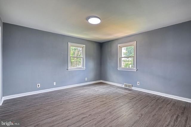 unfurnished room with a wealth of natural light and dark hardwood / wood-style floors