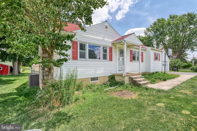 view of front of home featuring a front yard and central AC