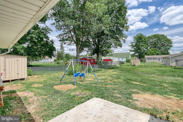 view of yard with a playground, a patio area, and a storage shed