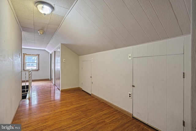 additional living space with hardwood / wood-style floors and lofted ceiling