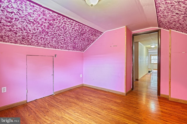 additional living space featuring hardwood / wood-style floors and lofted ceiling