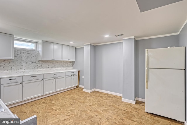 kitchen with decorative backsplash, white refrigerator, ornamental molding, and white cabinetry