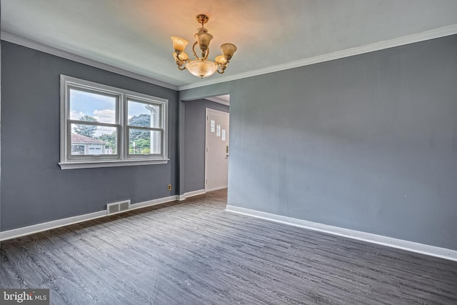 empty room featuring dark wood-type flooring, ornamental molding, and an inviting chandelier