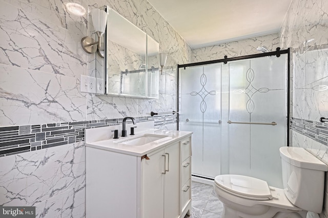 bathroom with a shower with door, vanity, tile walls, and toilet