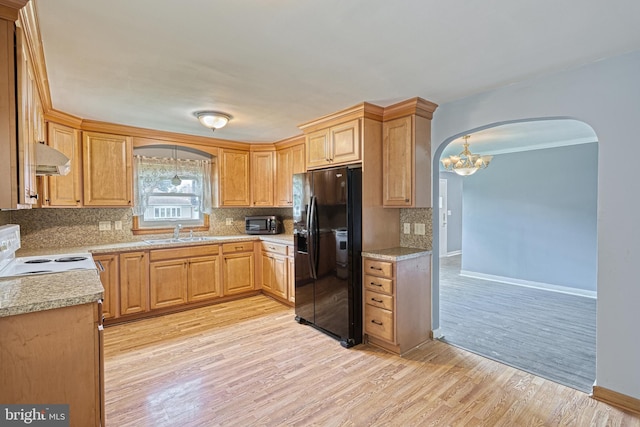 kitchen with sink, an inviting chandelier, light hardwood / wood-style flooring, black fridge with ice dispenser, and range