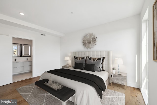 bedroom featuring hardwood / wood-style floors and ensuite bath