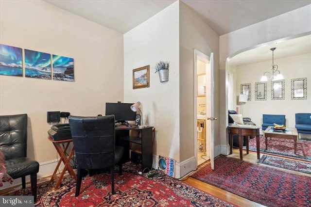 office featuring wood-type flooring and a notable chandelier