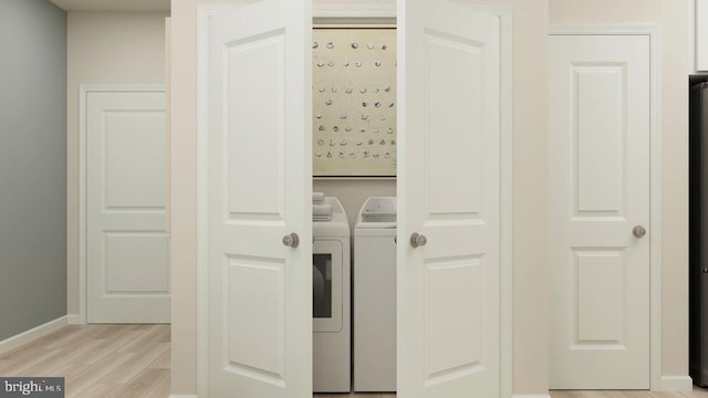 washroom with washer and dryer and light hardwood / wood-style flooring