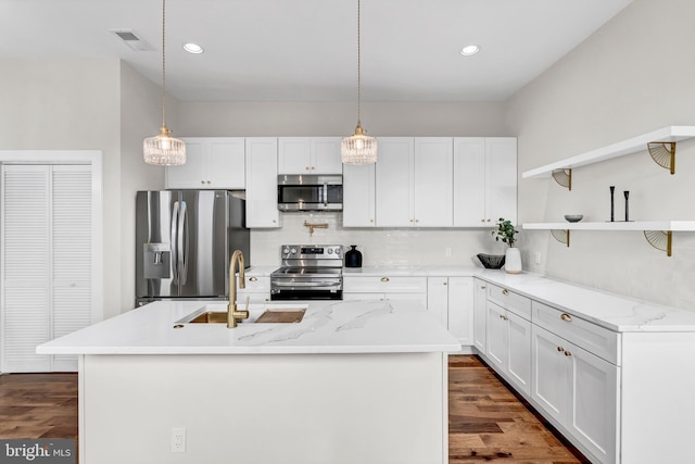 kitchen featuring white cabinets, appliances with stainless steel finishes, a center island with sink, and sink