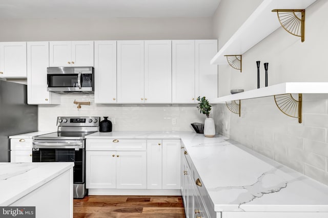 kitchen featuring white cabinets, light stone countertops, and appliances with stainless steel finishes