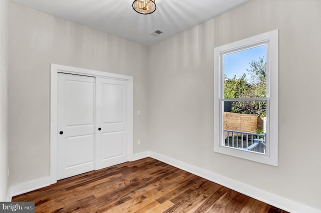 unfurnished bedroom featuring hardwood / wood-style flooring and a closet