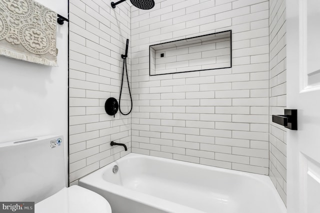 bathroom with tiled shower / bath combo and toilet