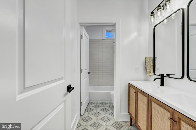 full bathroom featuring tiled shower / bath, vanity, and toilet