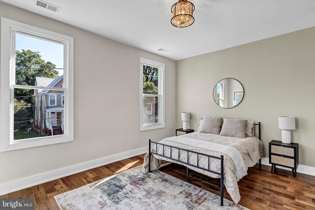 bedroom featuring dark hardwood / wood-style flooring and a chandelier