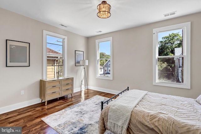 bedroom featuring dark hardwood / wood-style floors and a chandelier