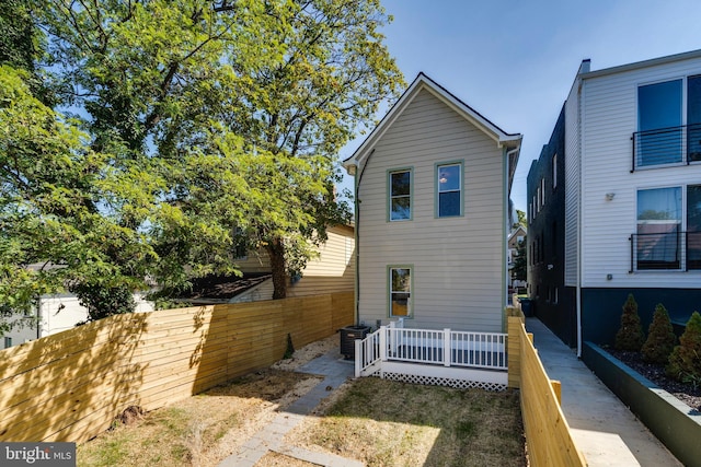 view of side of property with cooling unit and a wooden deck