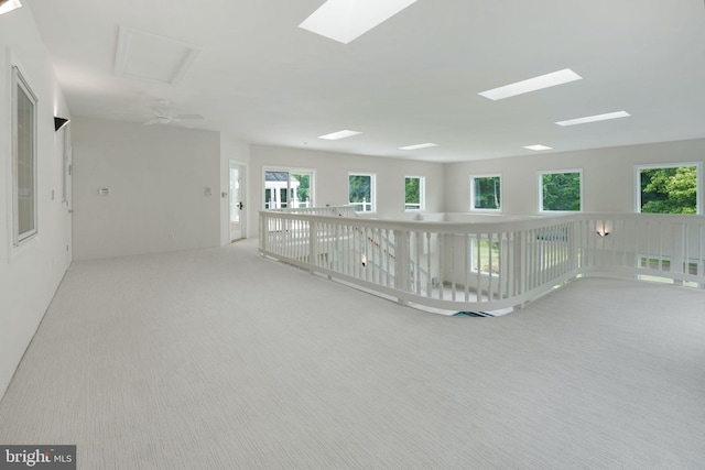 unfurnished room with ceiling fan, a healthy amount of sunlight, and light colored carpet