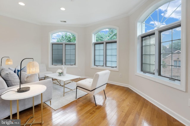 sitting room featuring crown molding and light hardwood / wood-style flooring