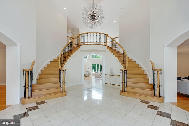 tiled foyer entrance featuring a high ceiling and a chandelier