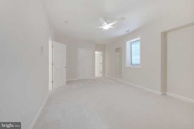 spare room featuring ceiling fan and light colored carpet