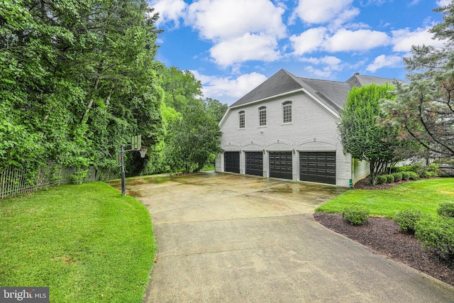 view of side of home featuring a garage and a lawn