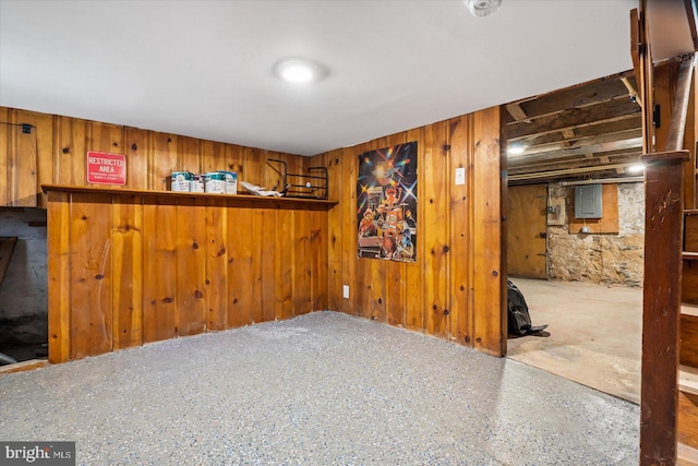 basement with indoor bar, electric panel, and wooden walls