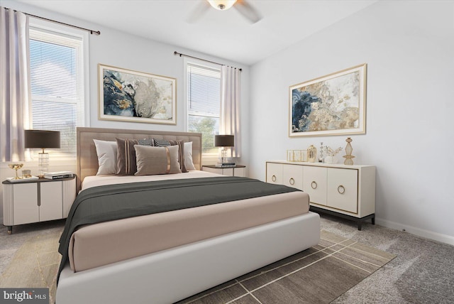 bedroom with dark carpet, multiple windows, and ceiling fan