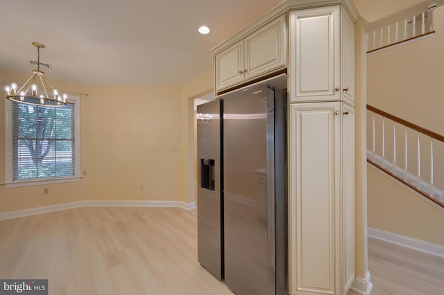 kitchen featuring an inviting chandelier, stainless steel refrigerator with ice dispenser, hanging light fixtures, light hardwood / wood-style flooring, and cream cabinetry